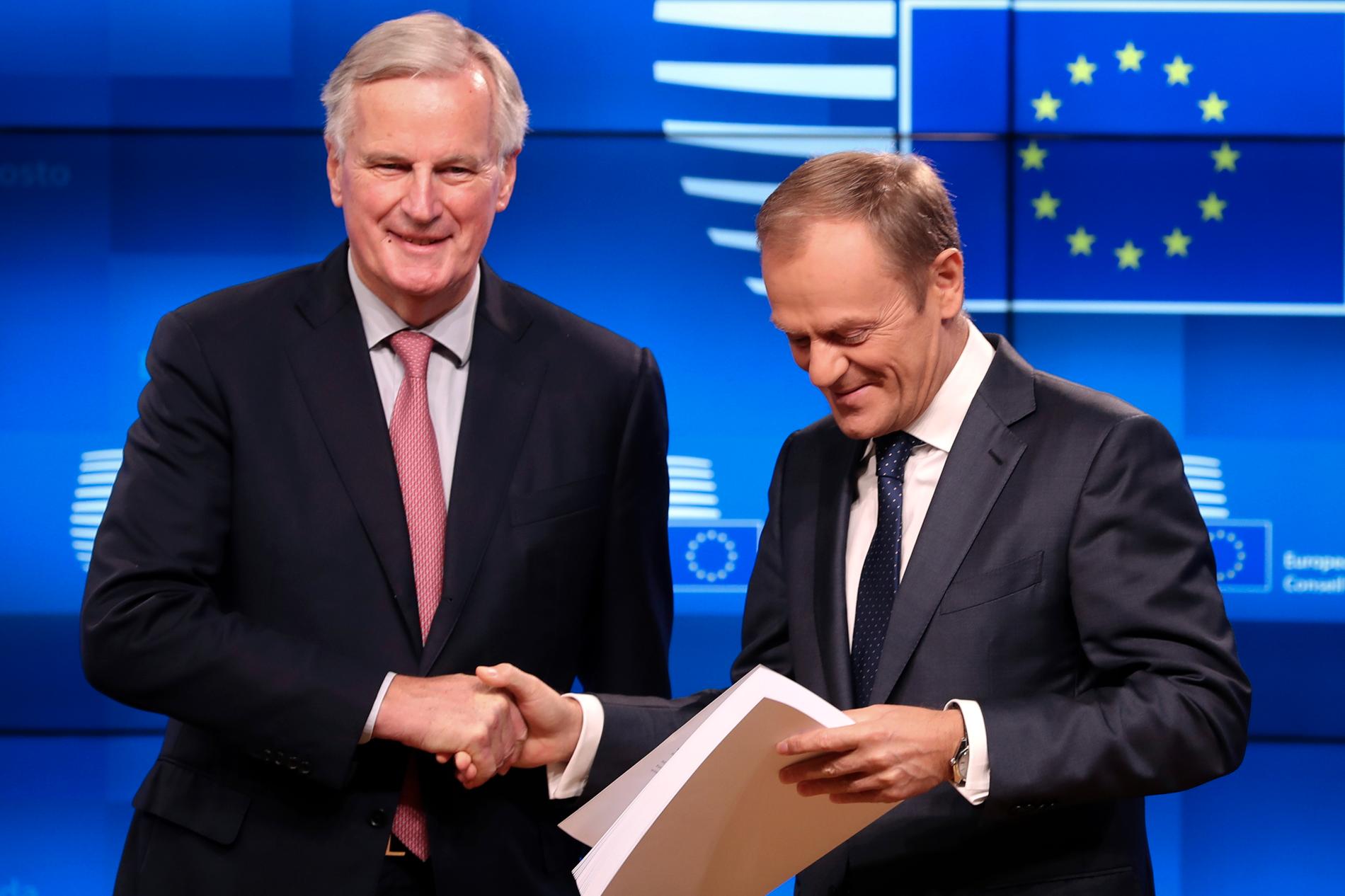 EU:s chefsförhandlare om brexit, Michel Barnier (till vänster), lämnar över utkastet till brexitavtalet till EU:s permanente rådsordförande Donald Tusk under deras presskonferens i Bryssel på torsdagen.