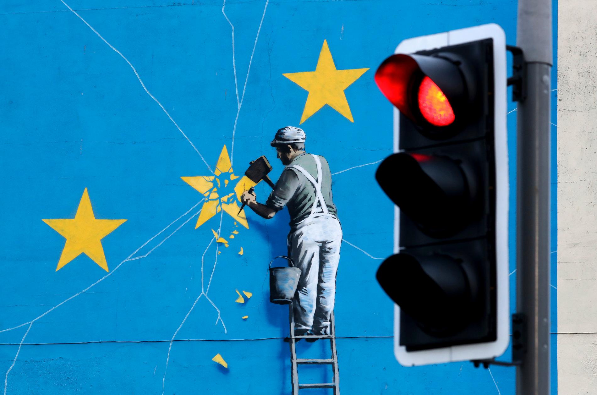 En muralmålning av konstnären Banksy föreställande en arbetare som knackar bort en stjärna på EU:s flagga. På onsdagen håller det konservativa partiet i Storbritannien förtroendeomröstning om sin partiledare Theresa May, en omröstning som påverkar brexit. Arkivbild.