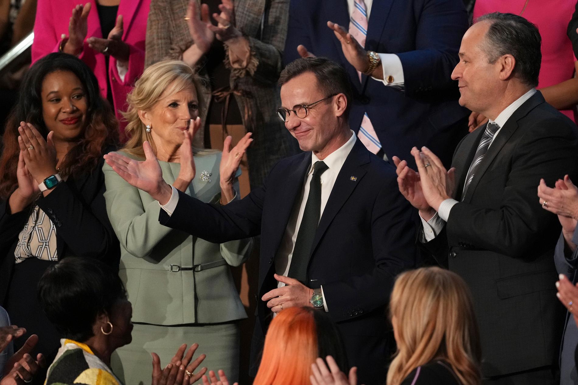 Ulf Kristersson tar nöjt emot applåder i Kapitolium. Presidenthustrun Jill Biden till vänster.