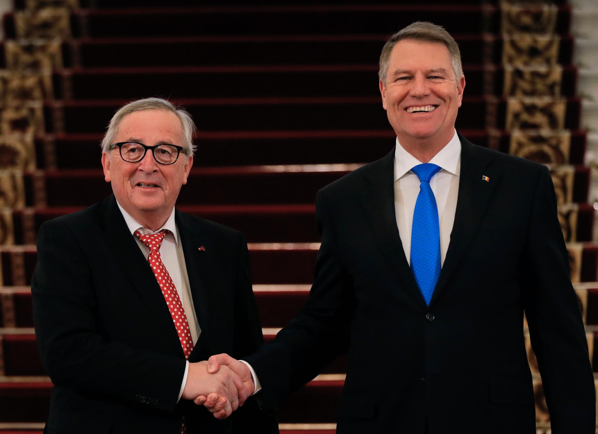 EU-kommissionens ordförande Jean-Claude Juncker och Rumäniens president Klaus Iohannis skakar hand i presidentpalatset i Bukarest.