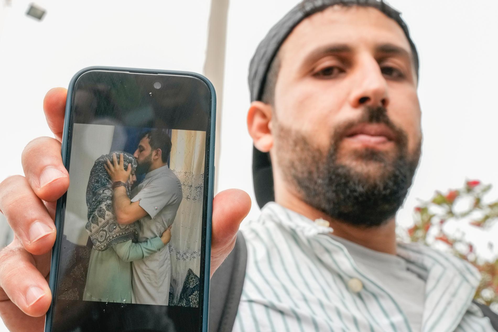 Kassem Abo Zeed visar en bild på sin fru Ezra som saknas efter katastrofen.