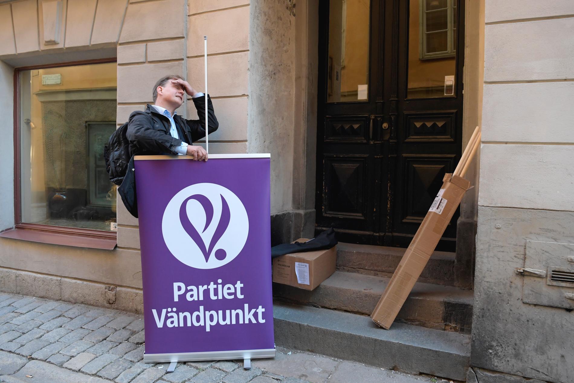 Partiet Vändpunkts talesperson Carl Schlyter sätter upp en partiaffisch utanför partikansliet i Gamla stan i Stockholm.