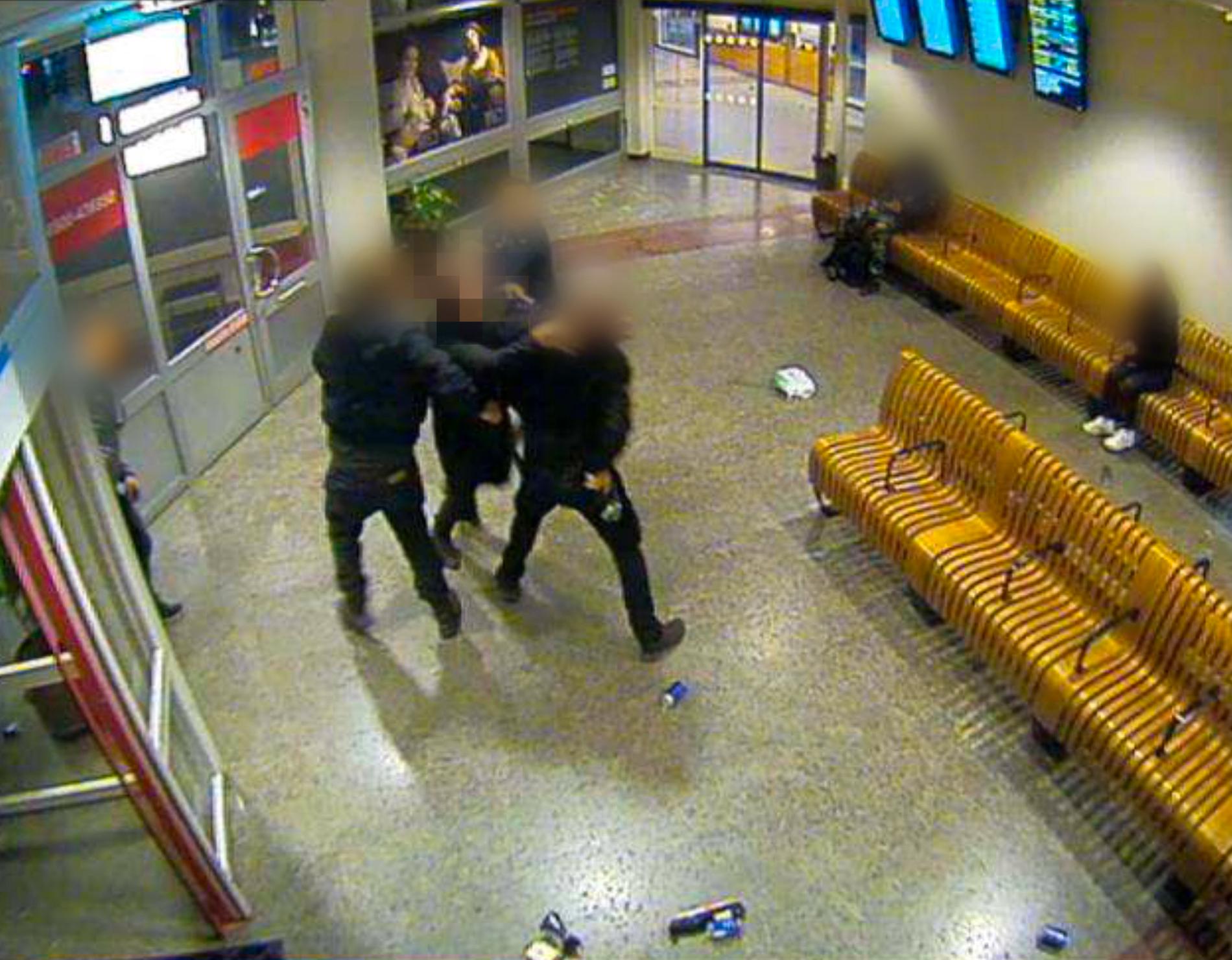 En av de tre männen kastar sig mot polismannen.  