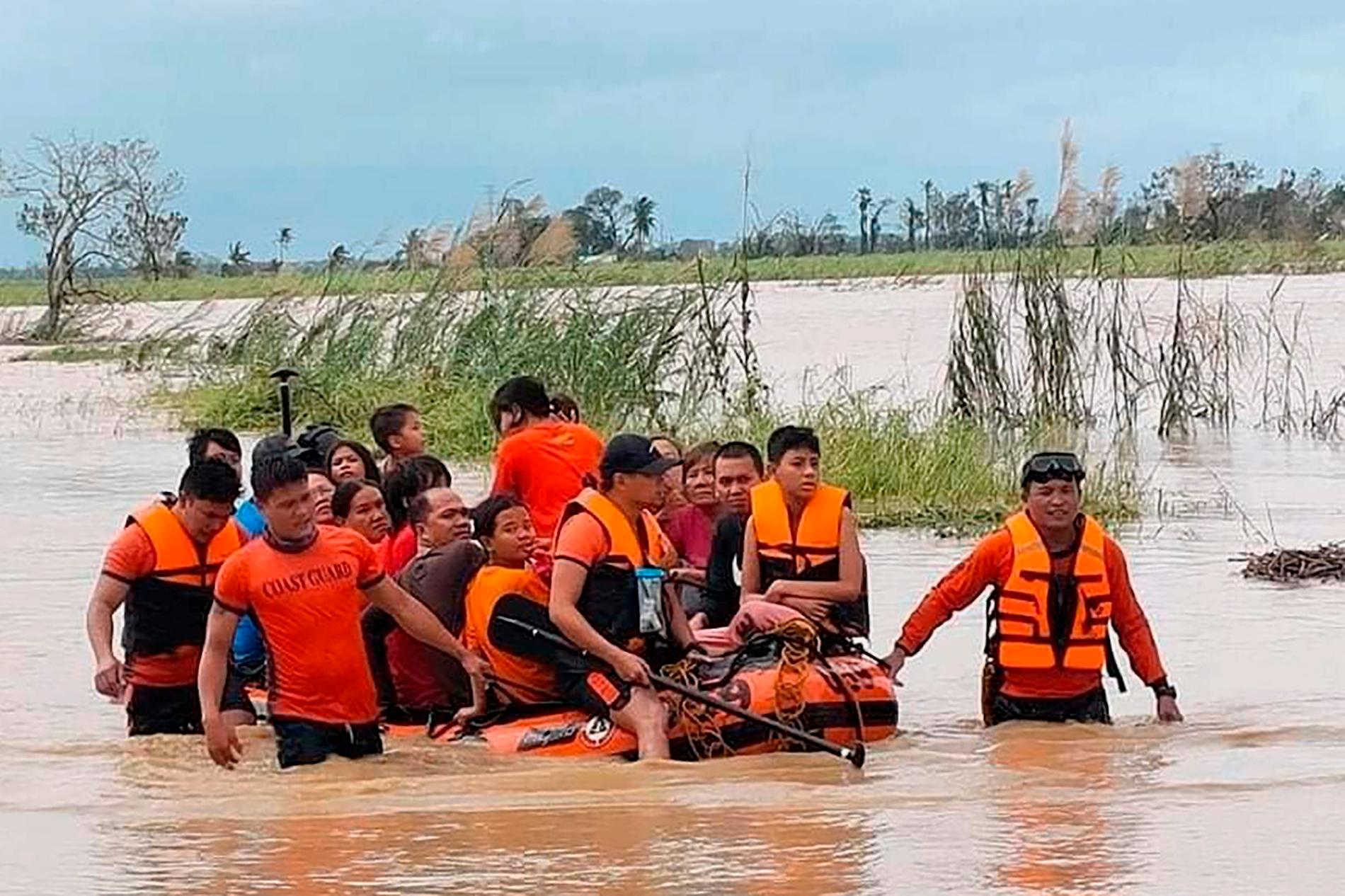 Räddningsarbetare drar en gummibåt med invånare som varit instängda i sina hem efter att deras by i Loboc i Bohol i centrala Filippinerna översvämmats.