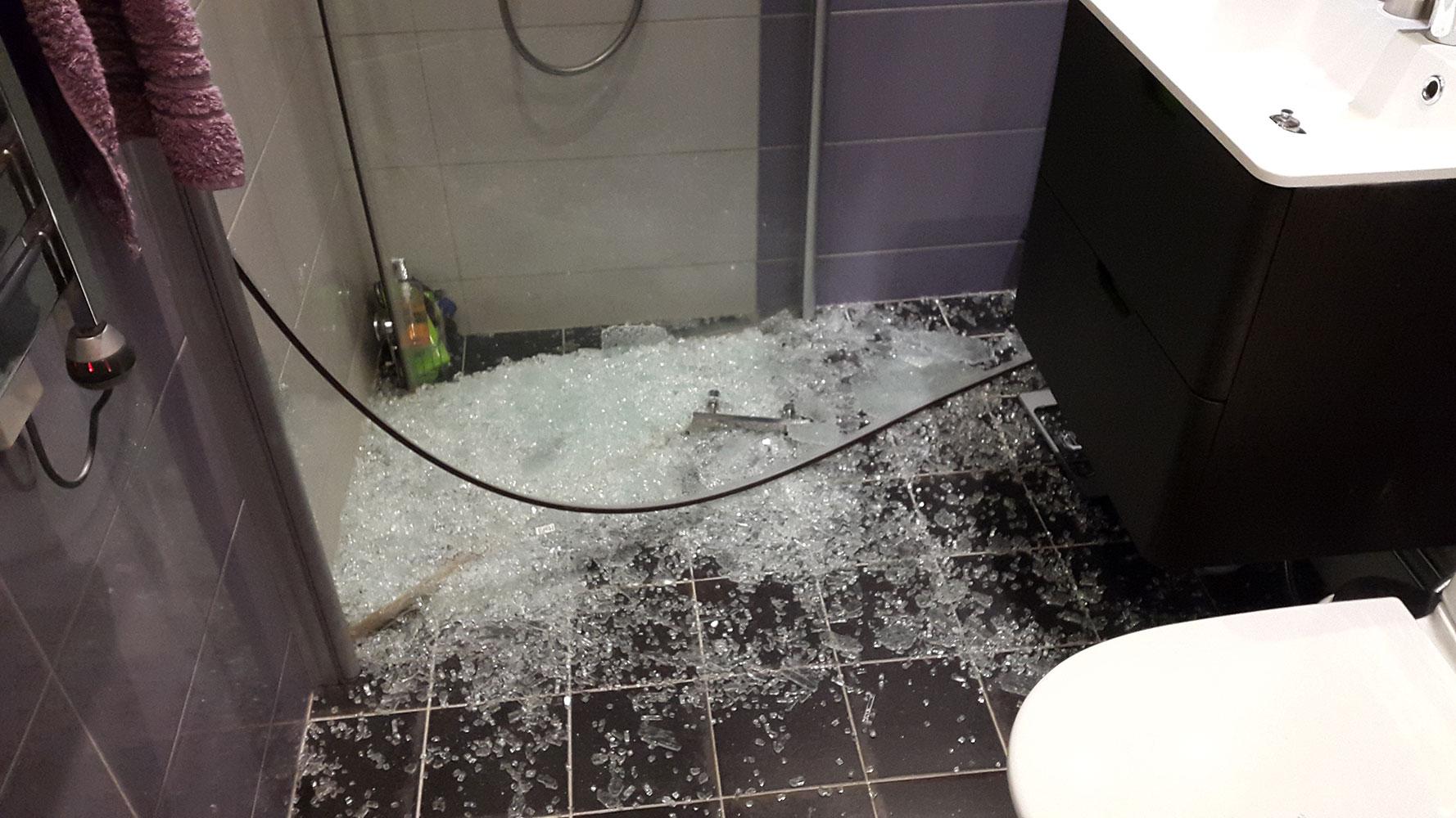 Krossat glas efter att duschväggen plötsligt exploderade.
