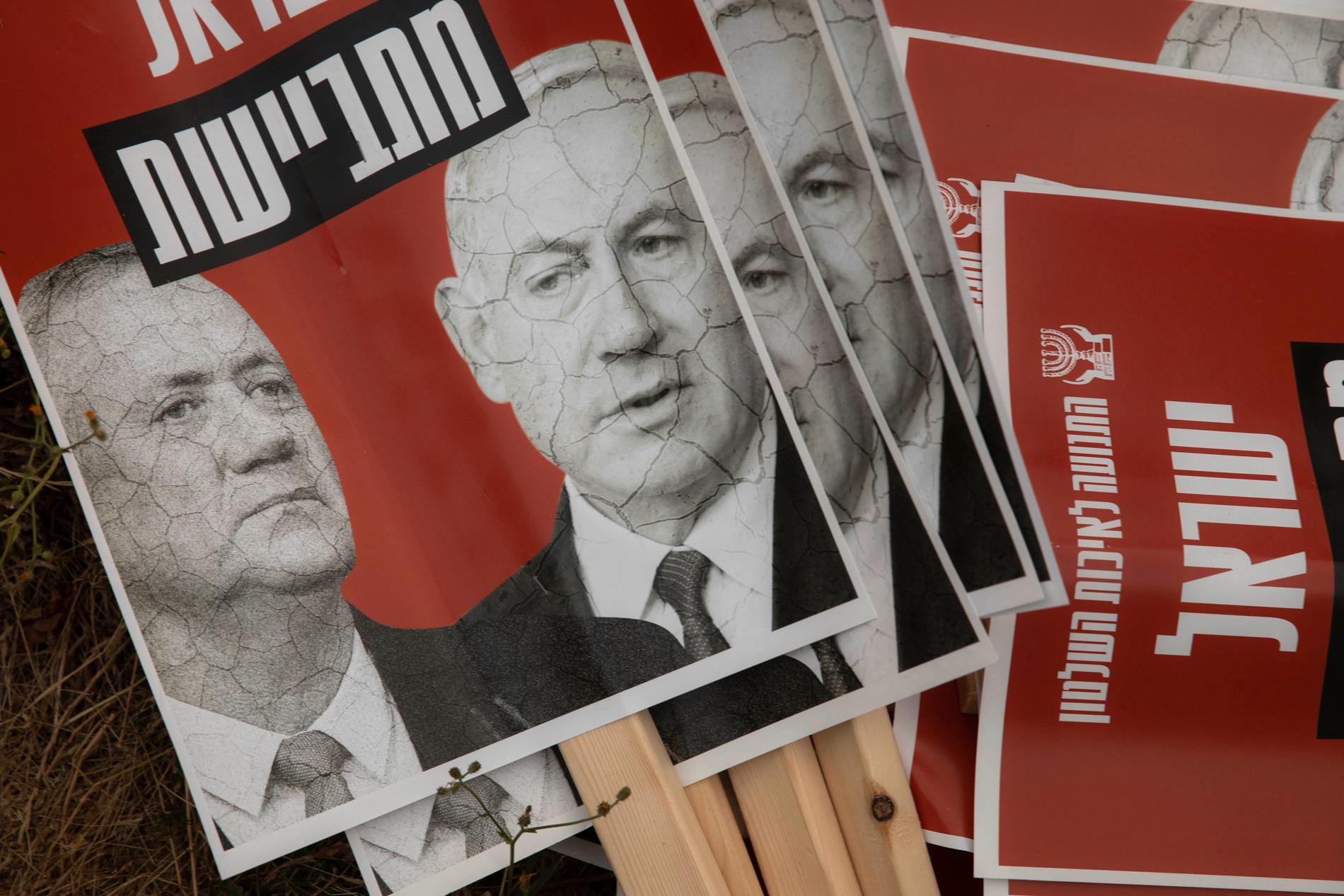 Israels premiärminister (till höger på plakatet) vill skjuta upp installationen av en ny regering med forne politiske fienden Benny Gantz.