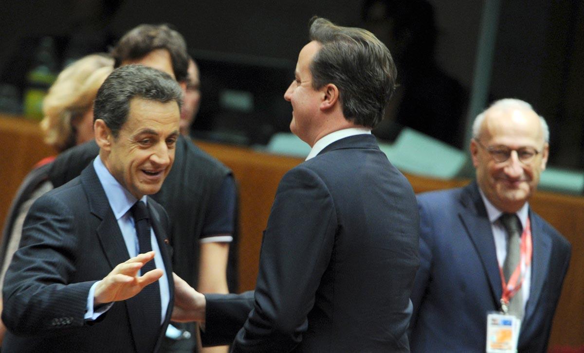 Cameron får nöja sig med att klappa Sarkozy på armen.