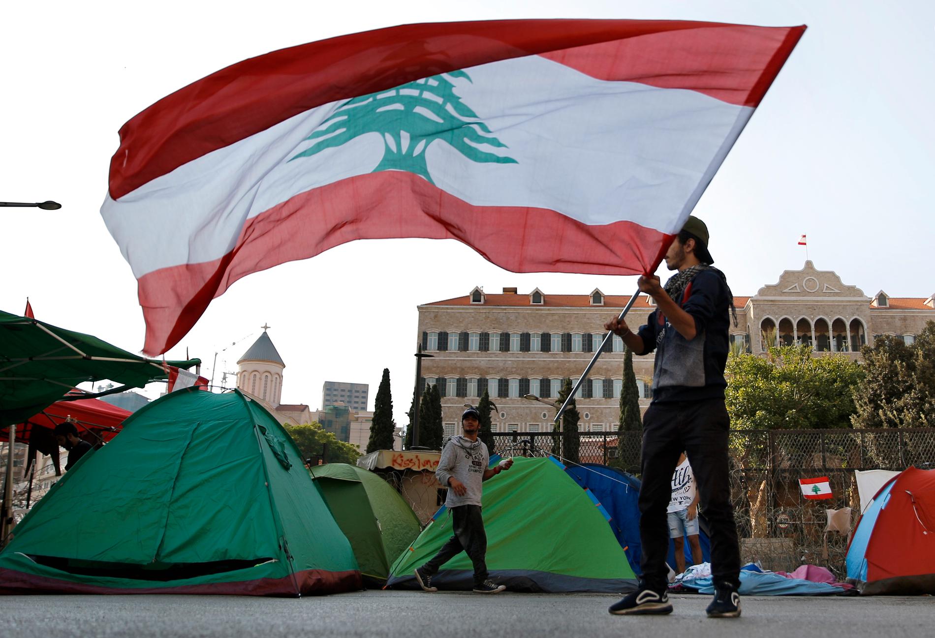 En demonstrant med den libanesiska flaggan under regeringskritiska protester i Libanons huvudstad Beirut den 31 oktober.