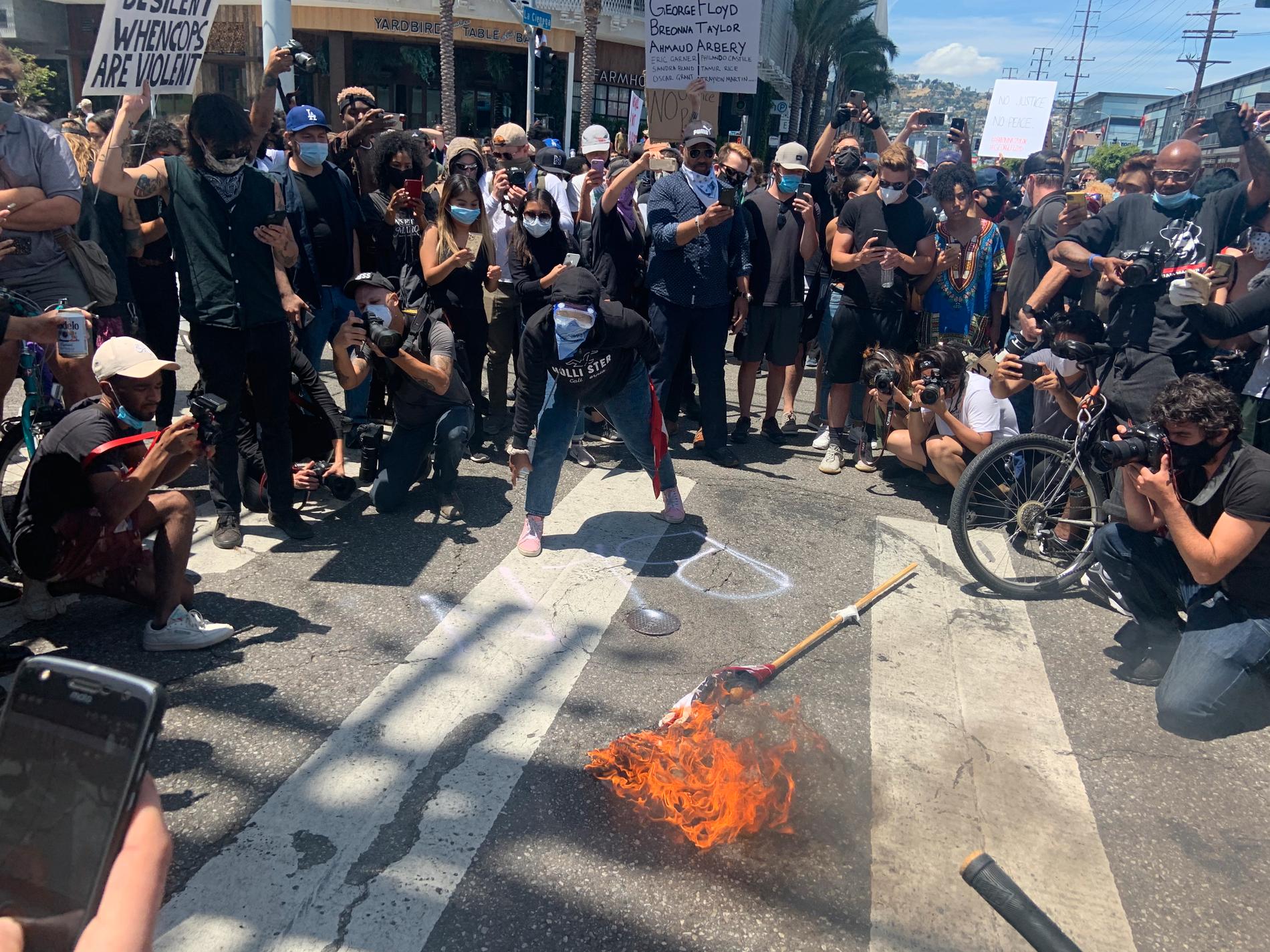 Demonstranter bränner USA:s flagga under protester i Los Angeles.