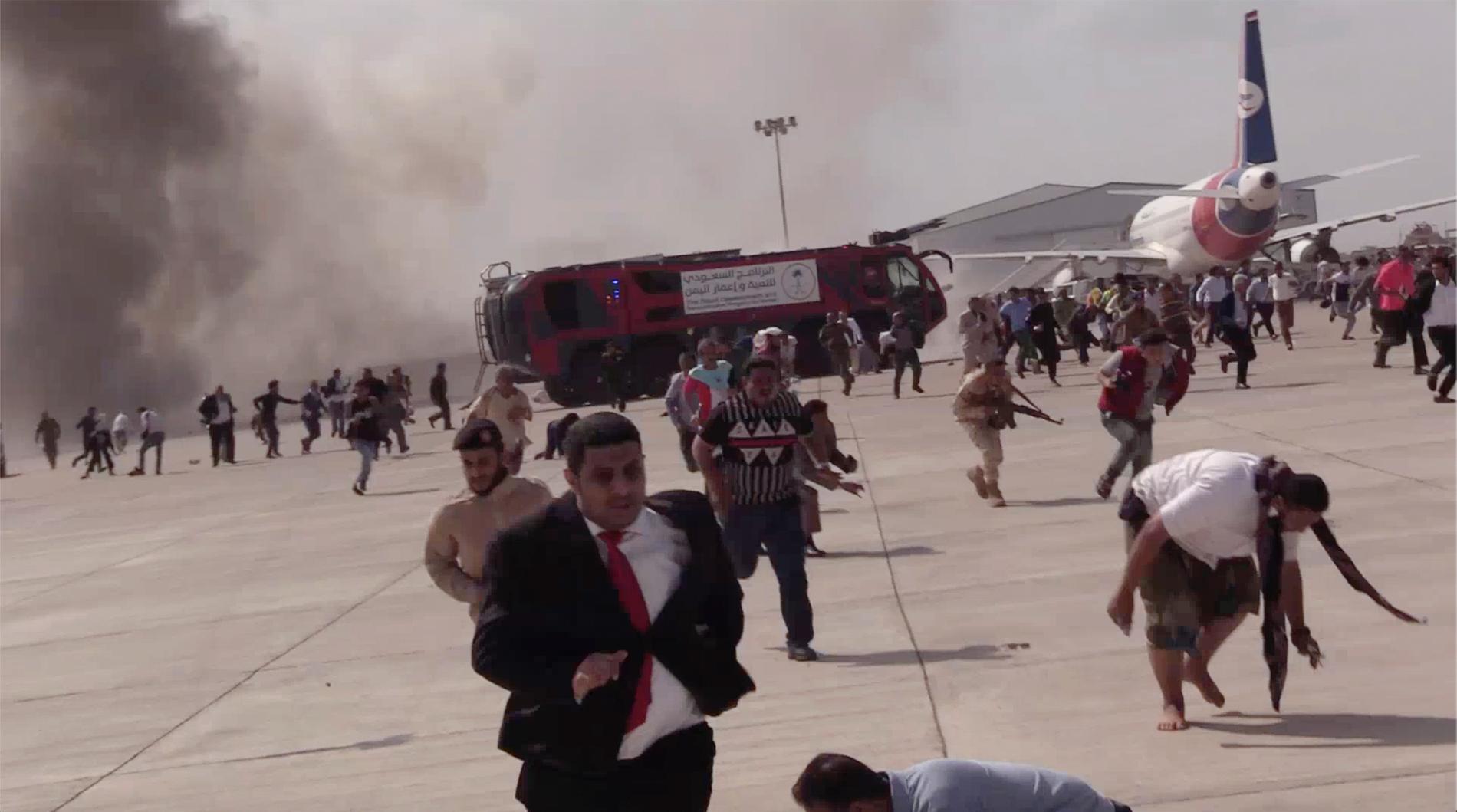Personer springer efter en explosionen på flygplatsen Aden, Jemen.