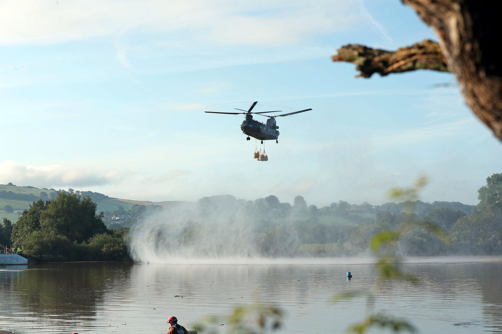 Helikoptern laddad med sandsäckar flyger vattenmagasinet Toddbrook som riskerar att brista.
