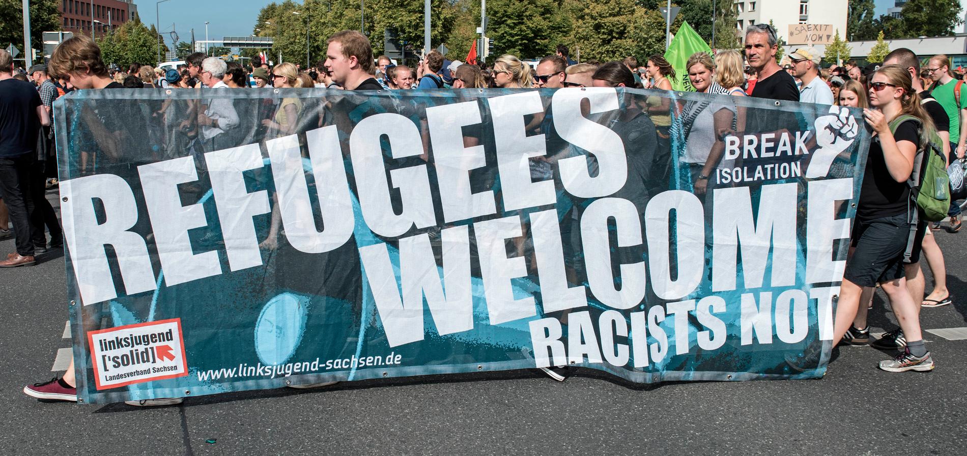 Demonstranter i Dresden, östra Tyskland, bär en banderoll med texten ”Refugees welcome – racists not” (”Flyktingar välkomna – inte rasister”).