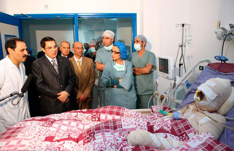 hans död skapade kaos i tunisien Mohamed Bouazizi, 26, sålde frukt och grönsaker för att överleva dagen. Förra månaden konfiskerade myndigheterna hans vagn. I ren desperation hällde han en dunk bensin över sig och tände på. Han fick svåra brännskador och president Zine El Abidine Ben Ali, här klädd i svart, besökte honom på sjukhuset. Bouazizi dog i början av året. Det var signalen som tusentals universitetsstudenter väntat på. Som svar på Bouazizis död tågade de ut i protest mot presidenten som styrt Tunisien med järnhand i drygt 23 år.