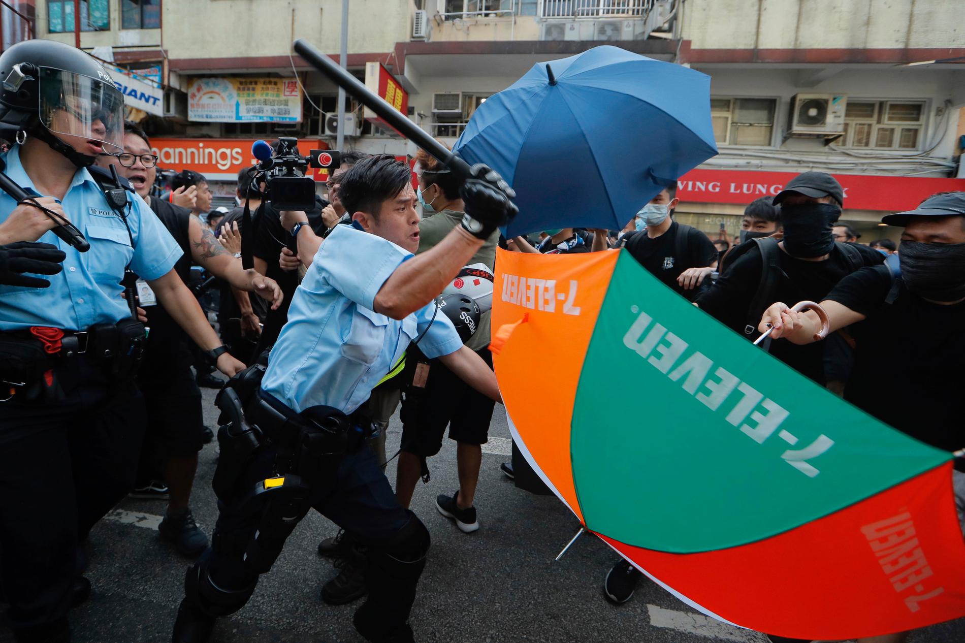En polis går till attack mot demonstranter i Hongkong under lördagens protester.