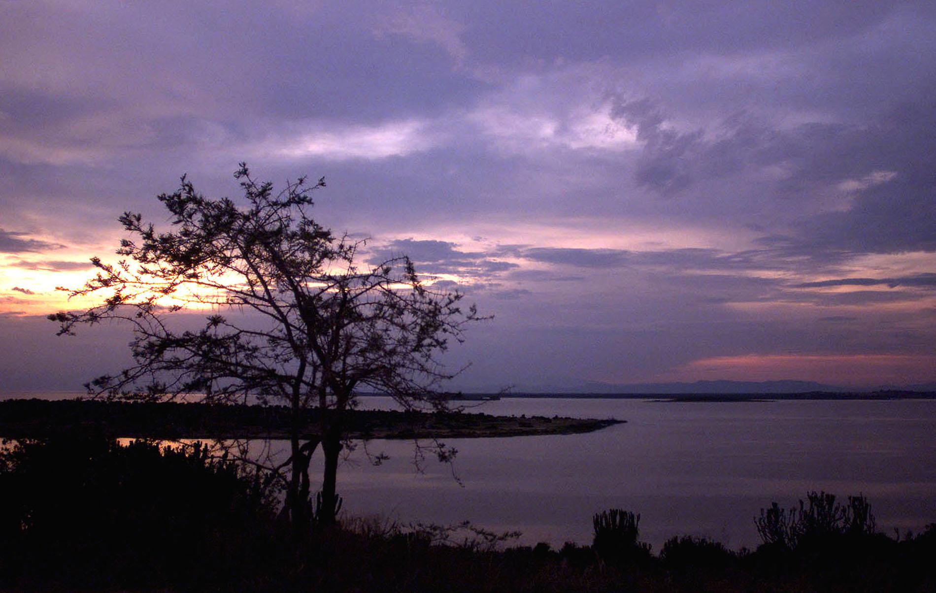Solnedgång vid en sjö vid Queen Elizabeth National Park i västra Uganda. Arkivbild.