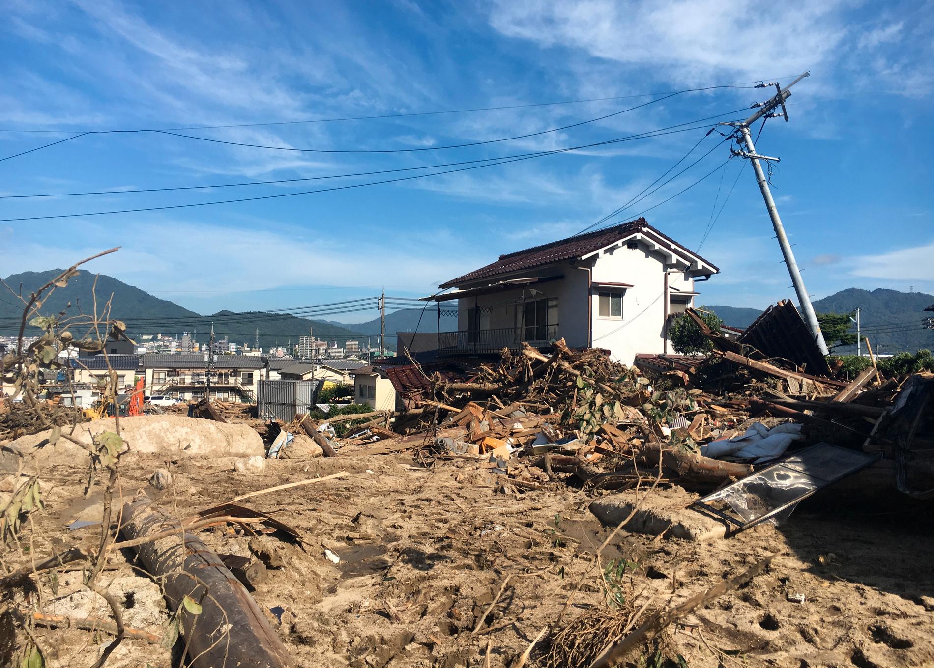 Förstörda hus i Hiroshima, i sydvästra Japan. Räddningspersonal söker igenom området efter saknade människor.