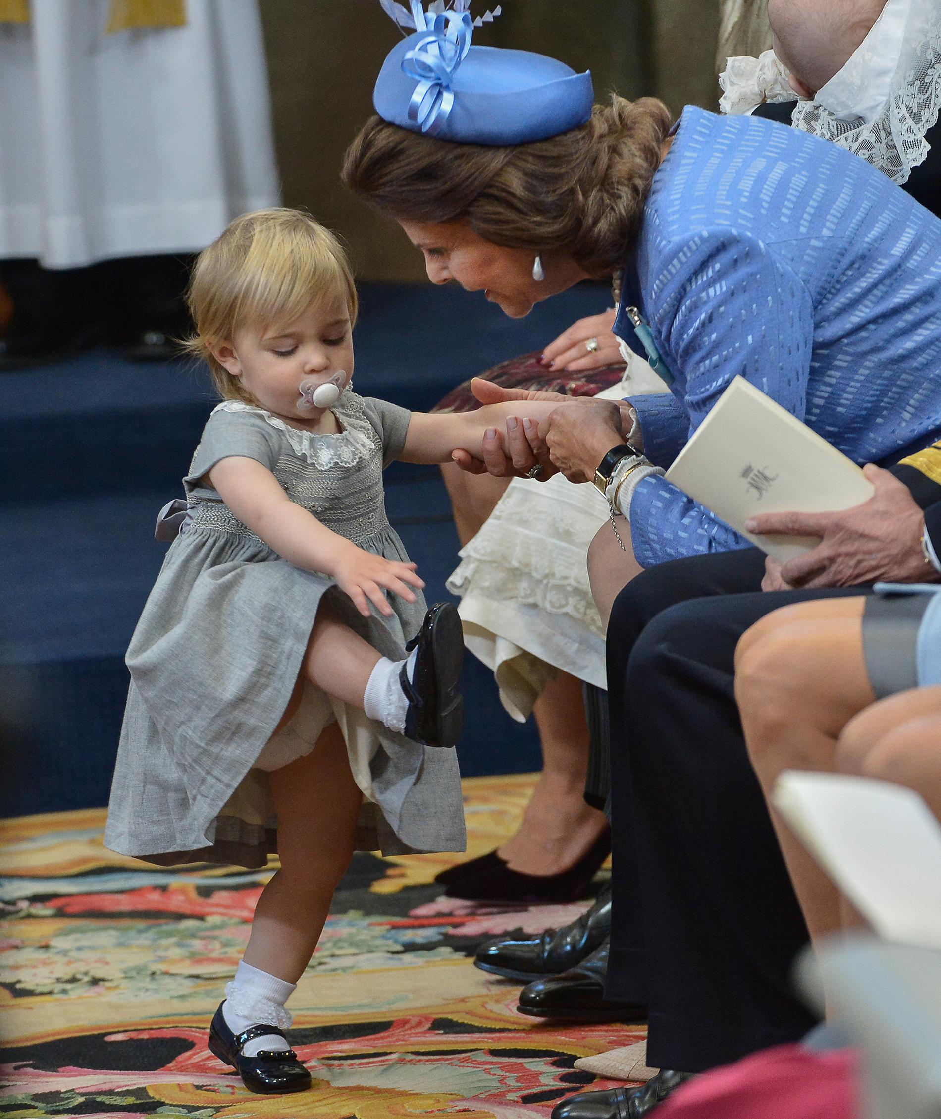 Prinsessan Leonore visar skon för drottning Silvia under prins Nicolas dop.