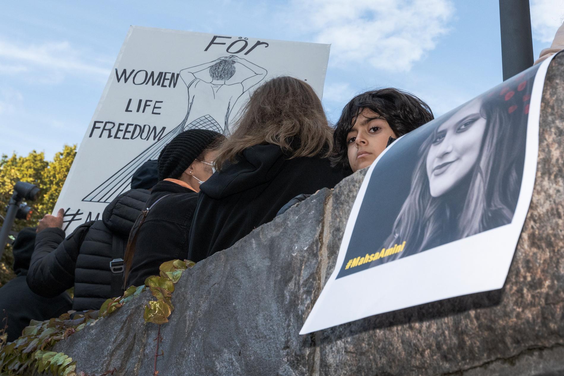 Demonstranter i Stockholm, med en bild av dödade iranskan Mahsa Amini. 