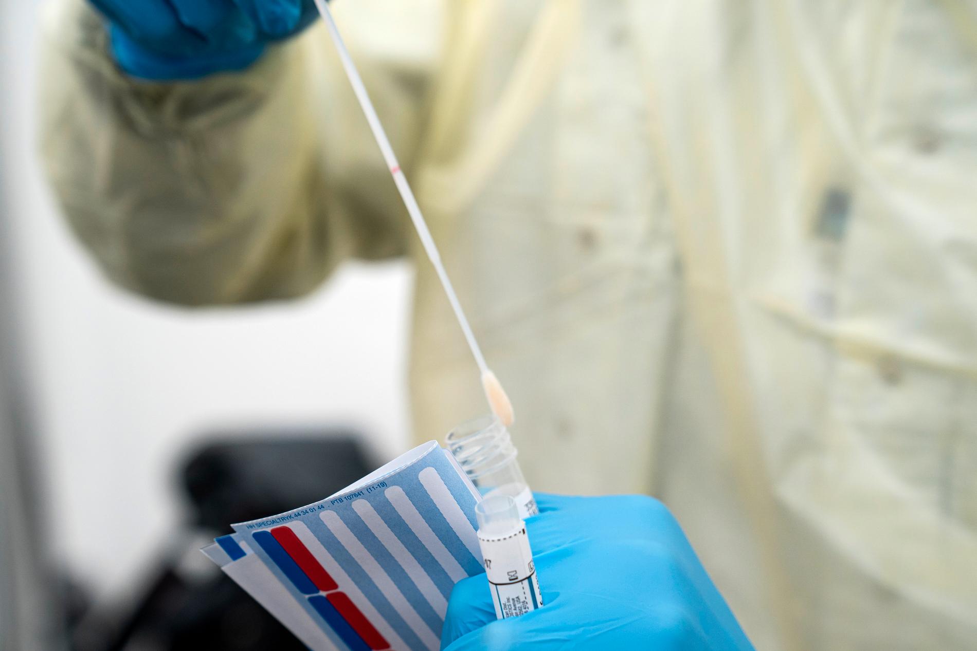 En dansk sjukvårdsarbetare tar fram testutrustning för coronaviruset. Nu ska alla med coronasymtom testas i Danmark