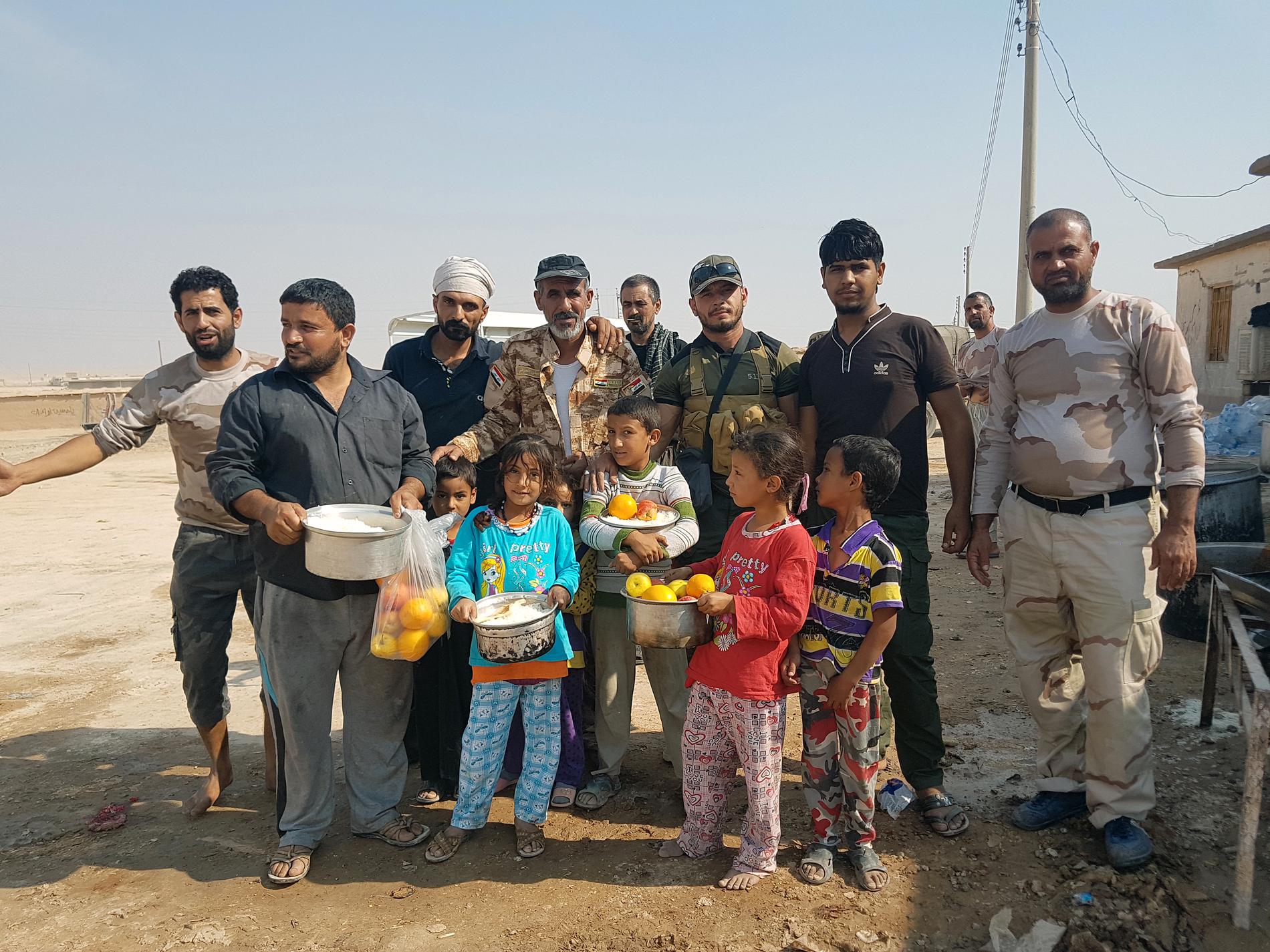 Shiamilisen PMU delar ut mat och vatten till flyktingar väster om Mosul.