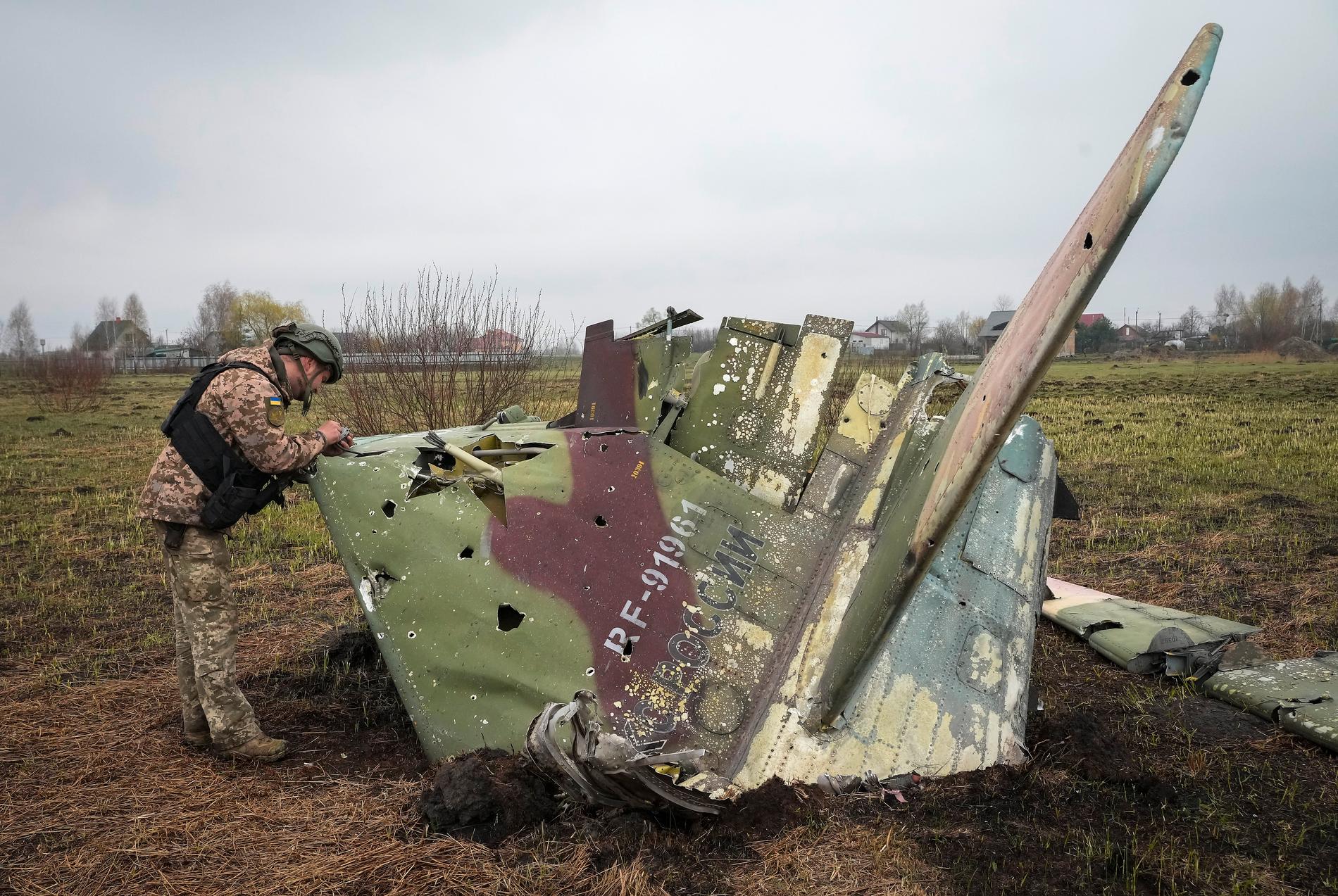 En ukrainsk soldat inspekterar vraket av ett nedskjutet ryskt stridsflygplan.