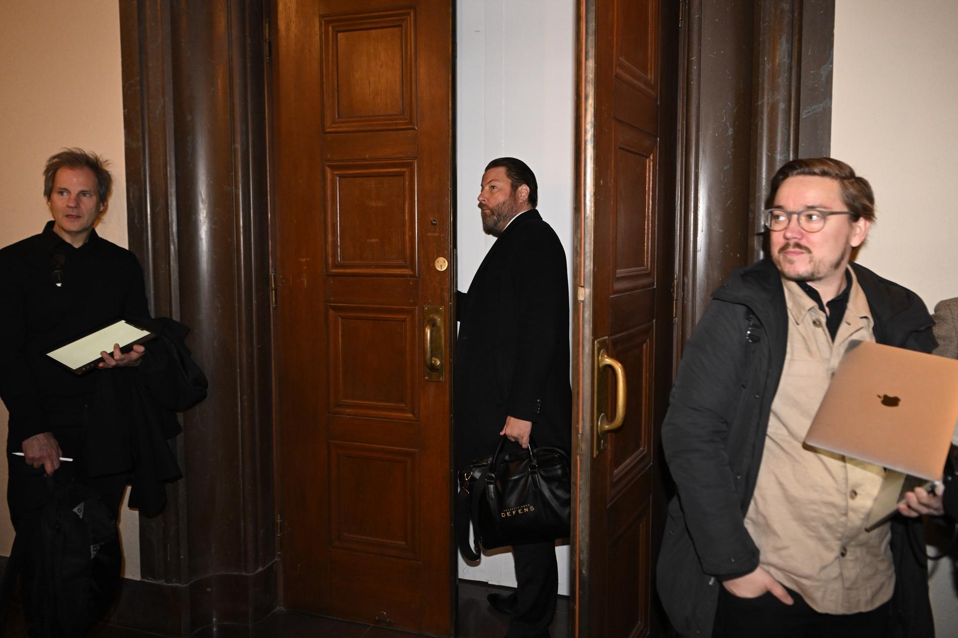 Advokat Anton Strand på väg in i rättsalen. Till höger syns Aftonbladets reporter John Granlund.