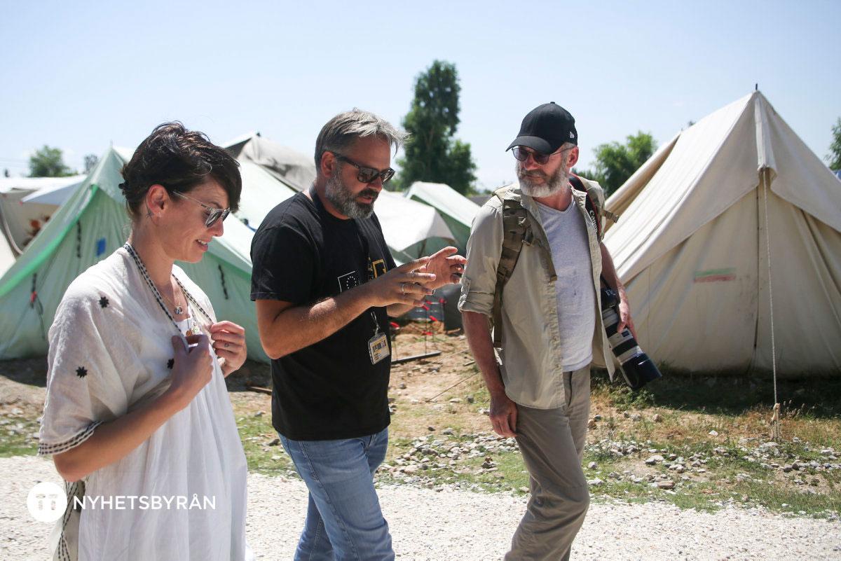 ”Game of thrones”-stjärnorna Liam Cunningham och Lena Headey guidas runt av Miltos Cherras i flyktinglägret Diavata i Grekland.
