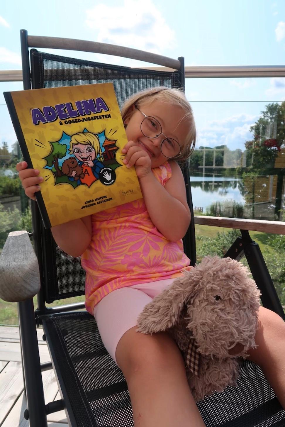 Adelina med sin bok: ”Adelina och gosedjursfesten – Med tecken som stöd!”