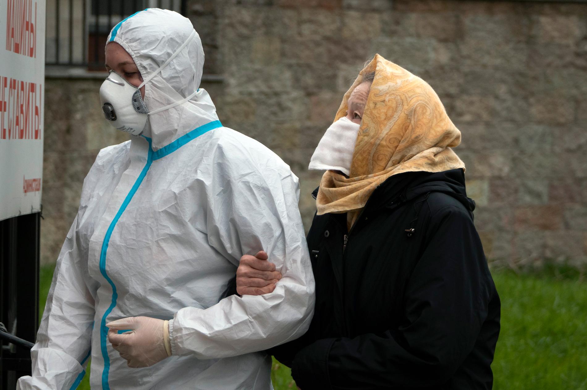 En vårdarbetare i skyddsutrustning med en patient som misstänks vara smittad av coronaviruset S:t Petersburg. Arkivbild.