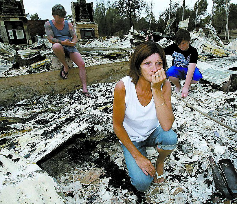 förlorat allt En familj bland resterna av sitt forna hem som förstörts av branden.