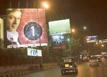 Megastjärnan Shahrukh Khan blickar ner från gigantiska reklamplakat längs vägarna.