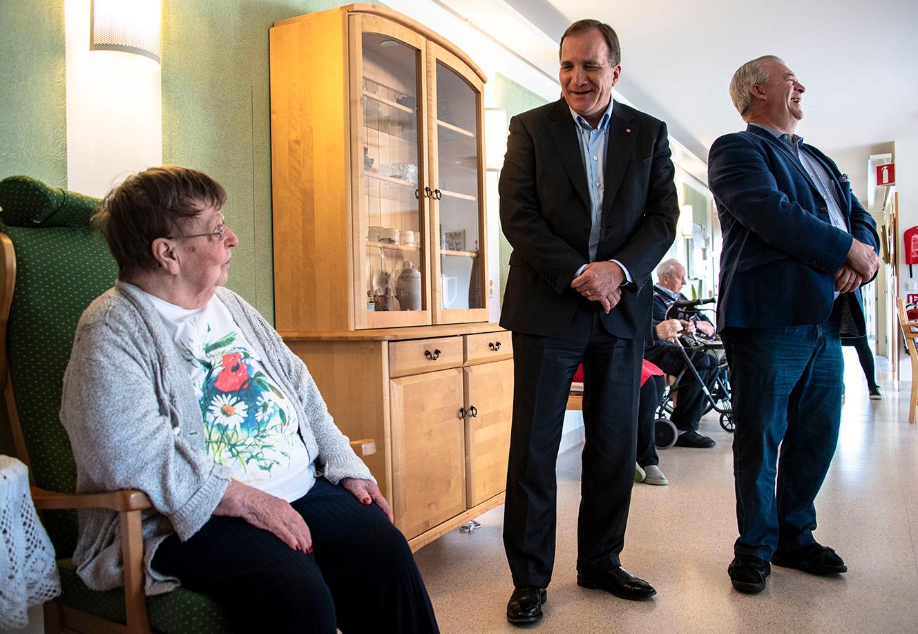 Statsminister Stefan Löfven (S) och landsbygdsminister Sven-Erik Bucht (S) hälsar på Evy Lindström när de besöker äldreboendet Solgården, Ödeshög.