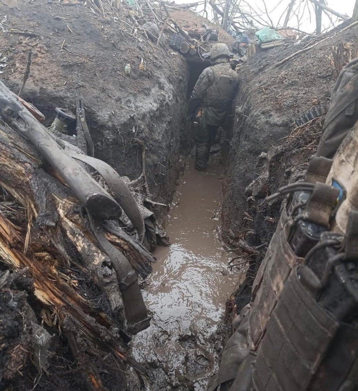 På bilder syns ukrainska soldater ta sig fram i leriga skyttegravar. 