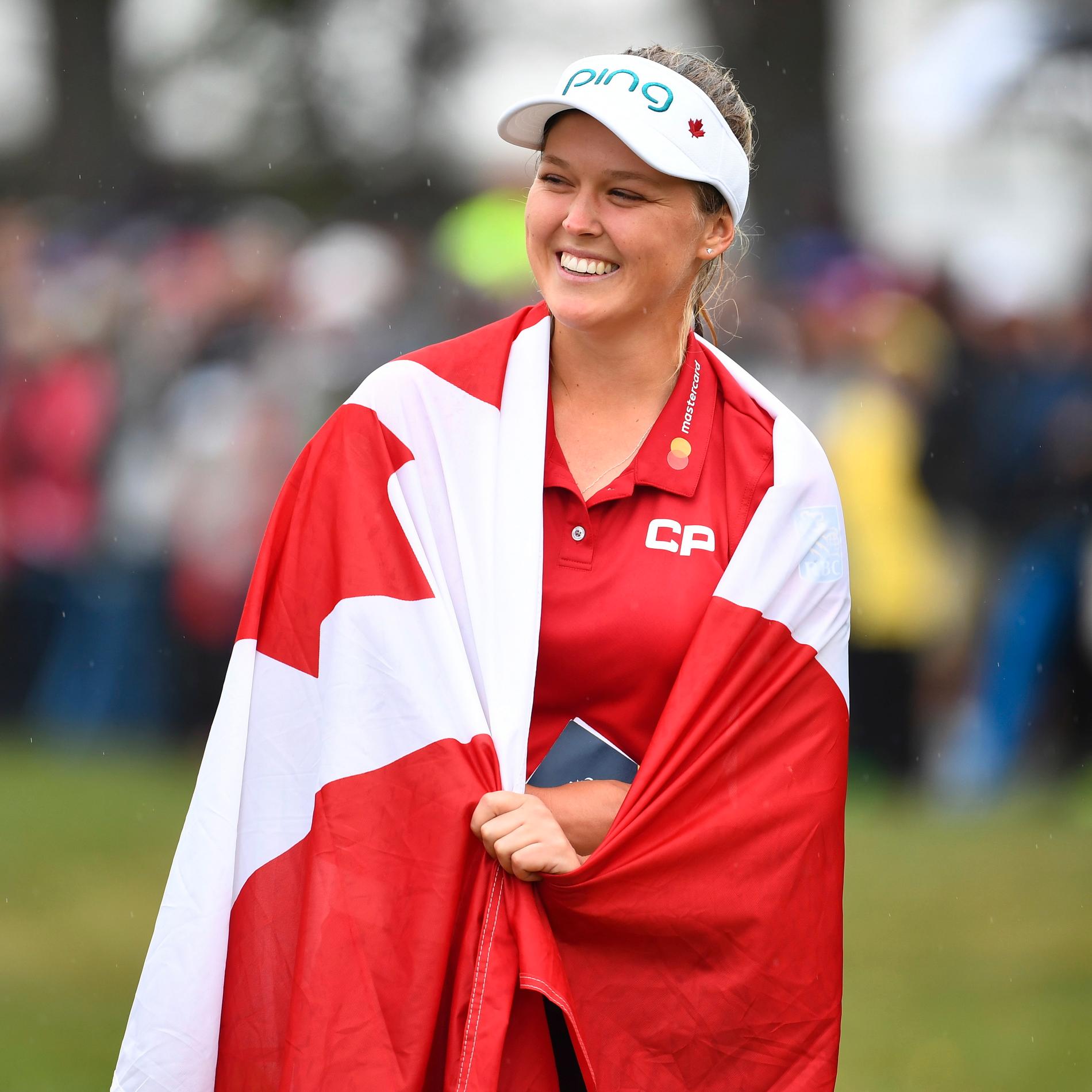 Hemmadottern Brooke Henderson fick en kanadensisk flagga att fira segern i.