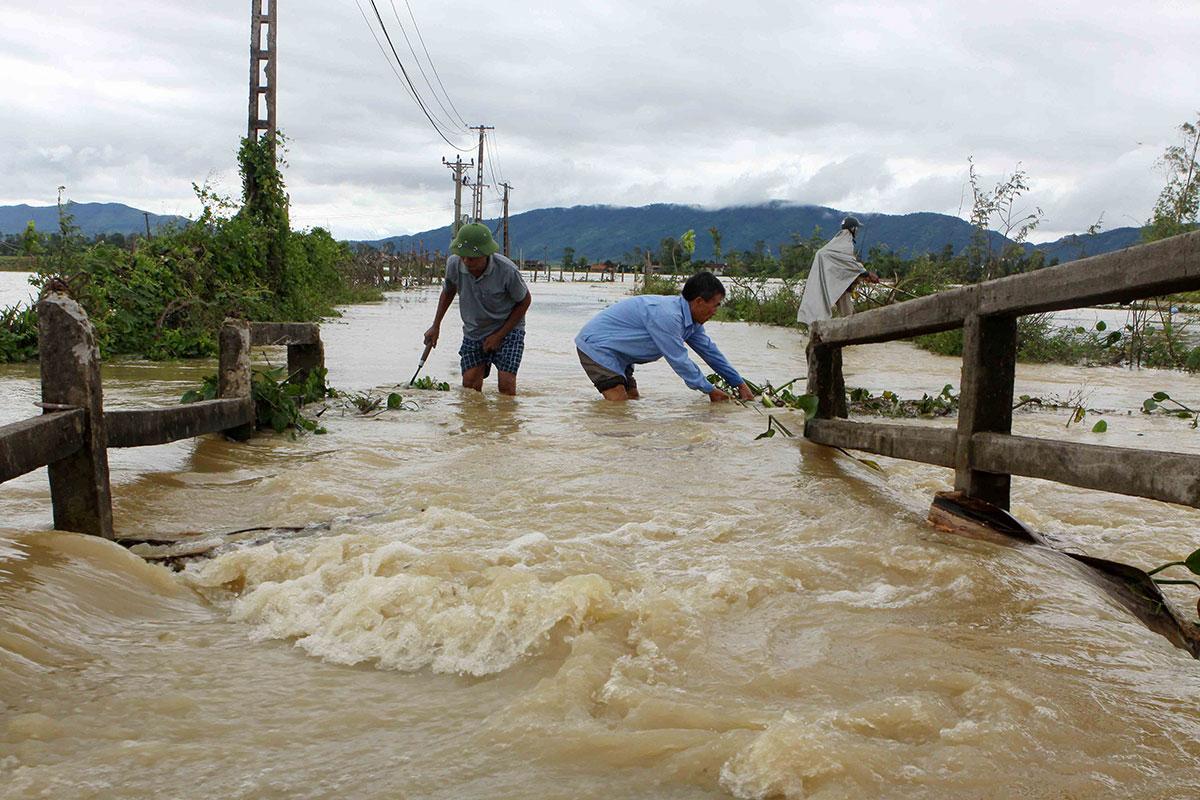 Män vadar genom vattenmassorna i provinsen Nghe An den 11 oktober. 
