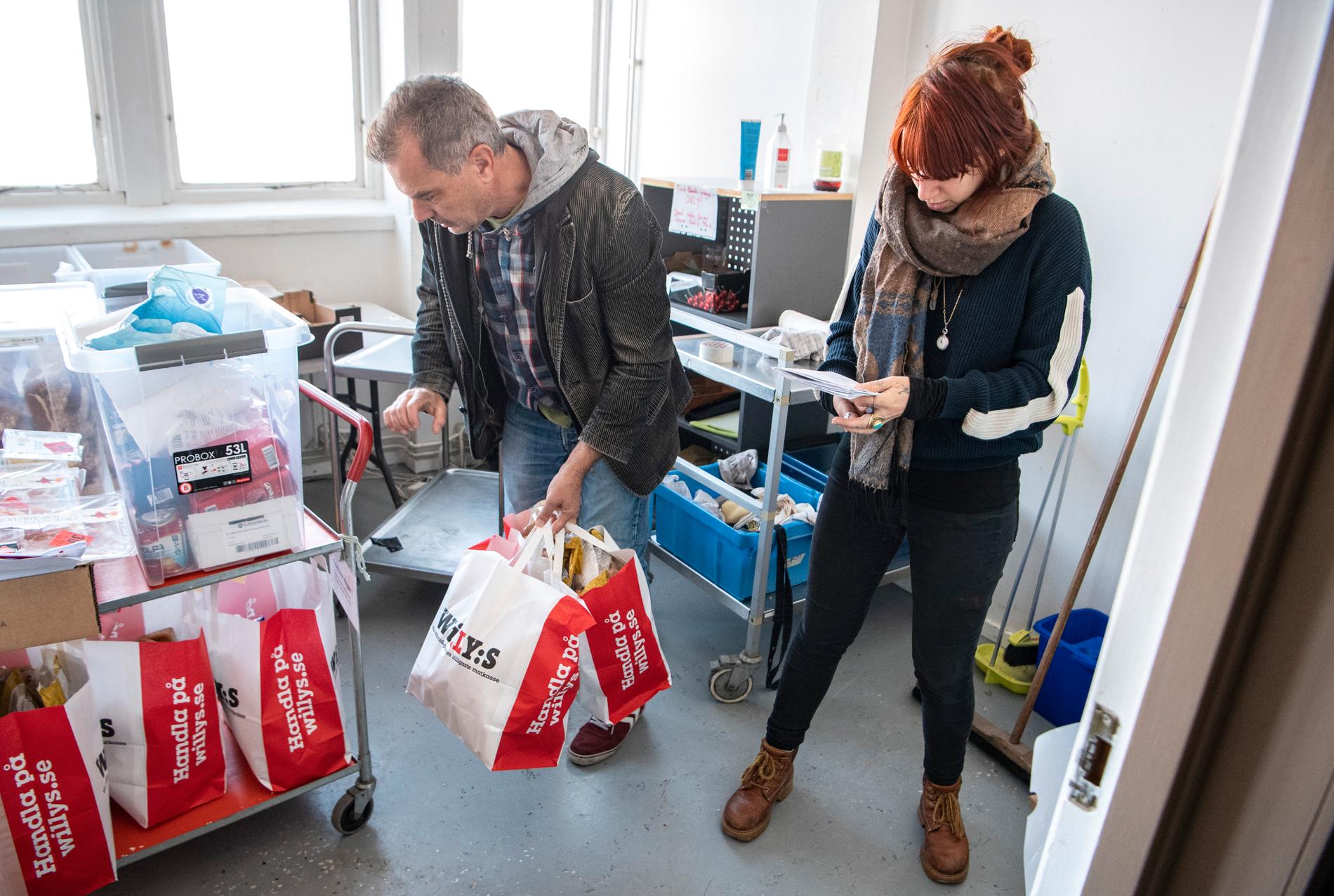Volontär Johanna Anemalm tar emot en leverans med matsvinn som volontären Ulf Carlsson varit ute och hämtat i Malmö.