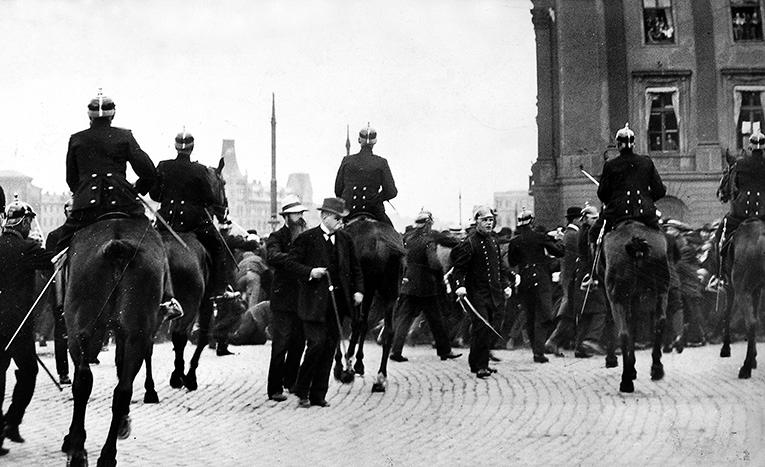 Hjalmar Branting (mustasch och käpp) mitt i polisens chock runt Gustav Adolfs torg den 5 juni 1917. Branting var på plats för att lugna demonstranterna – utan att lyckas.