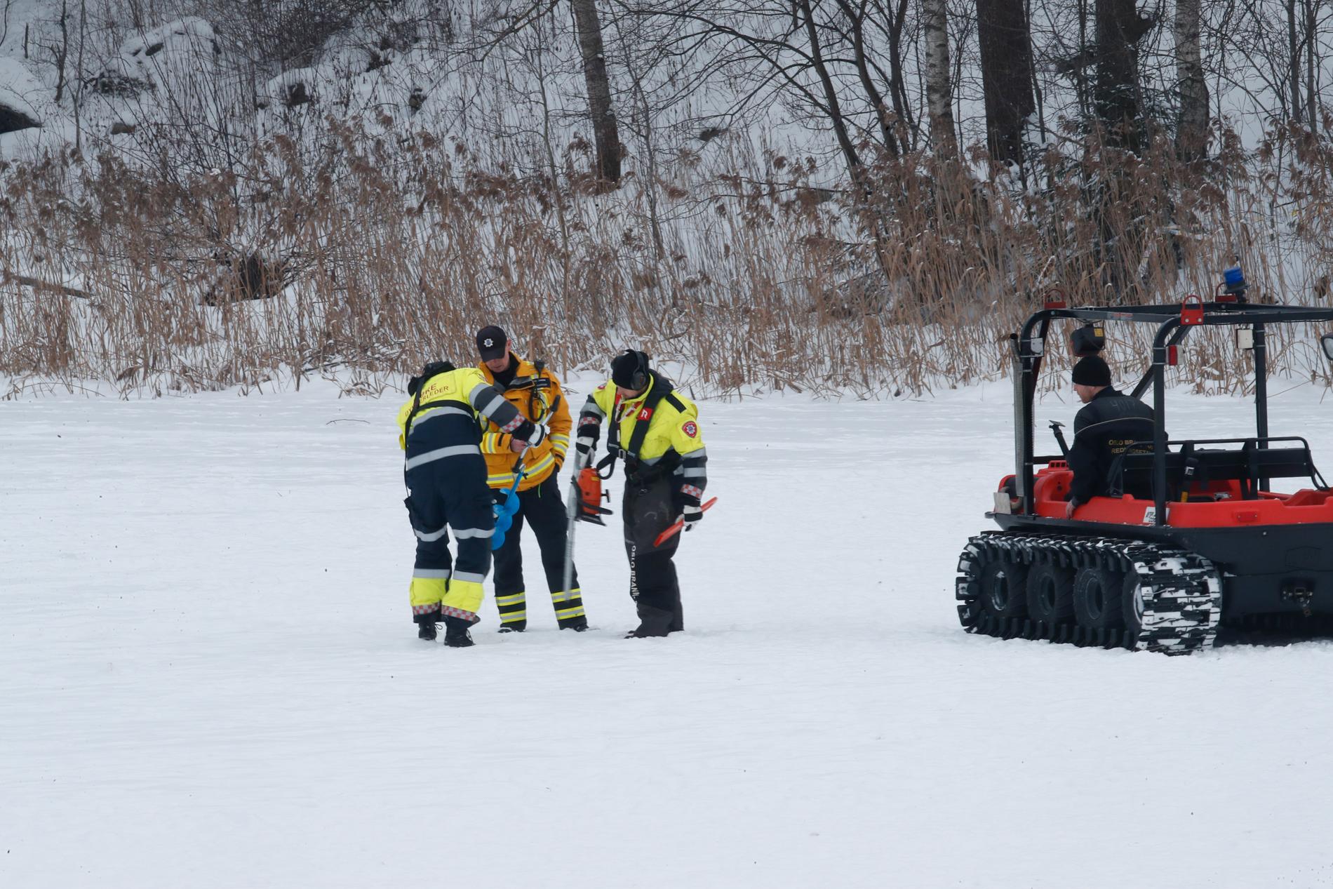 En grupp dykare sågar upp en vak i isen.