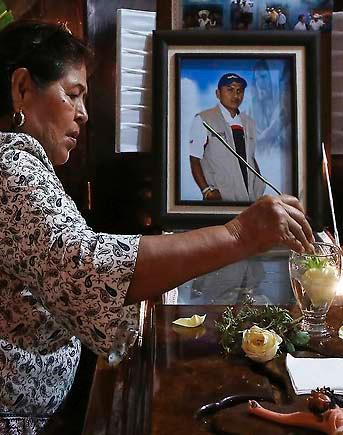 En kvinna hedrar den mördade journalisten Gumaro Perez, som sköts till döds under en julfest på sin sons skola.