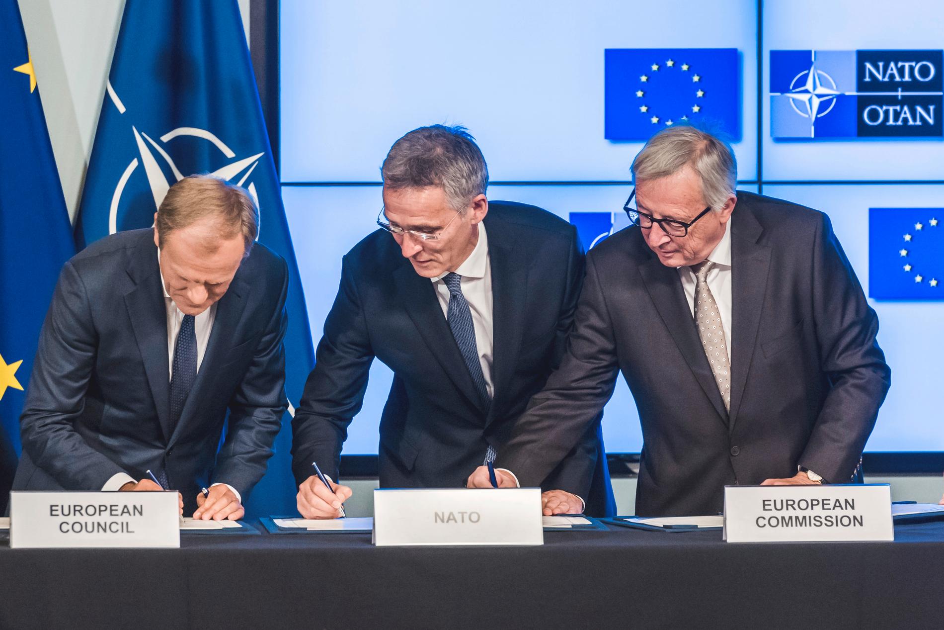EU:s permanente rådsordförande Donald Tusk, Natos generalsekreterare Jens Stoltenberg och EU-kommissionens ordförande Jean-Claude Juncker skriver under ett samarbetsavtal.