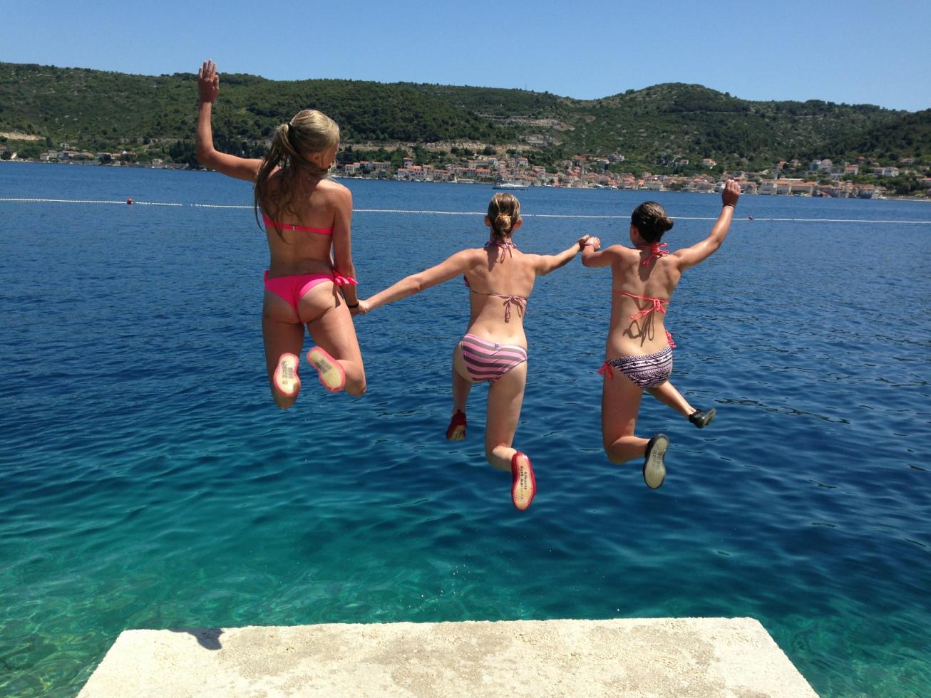 Lina, Julia och Minna hoppar i vattnet på ön Hvis.