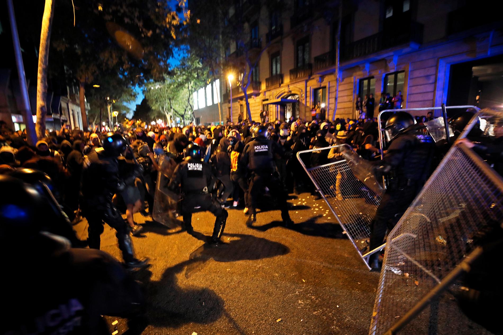Kravallpolis och demonstranter drabbar samman utanför den spanska regeringsbyggnaden i Barcelona på tisdagskvällen.