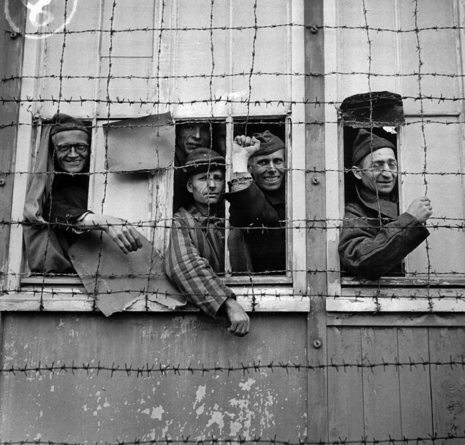 Fångar tittar ut från koncentrationslägret i Dachau i Tyskland 1945.