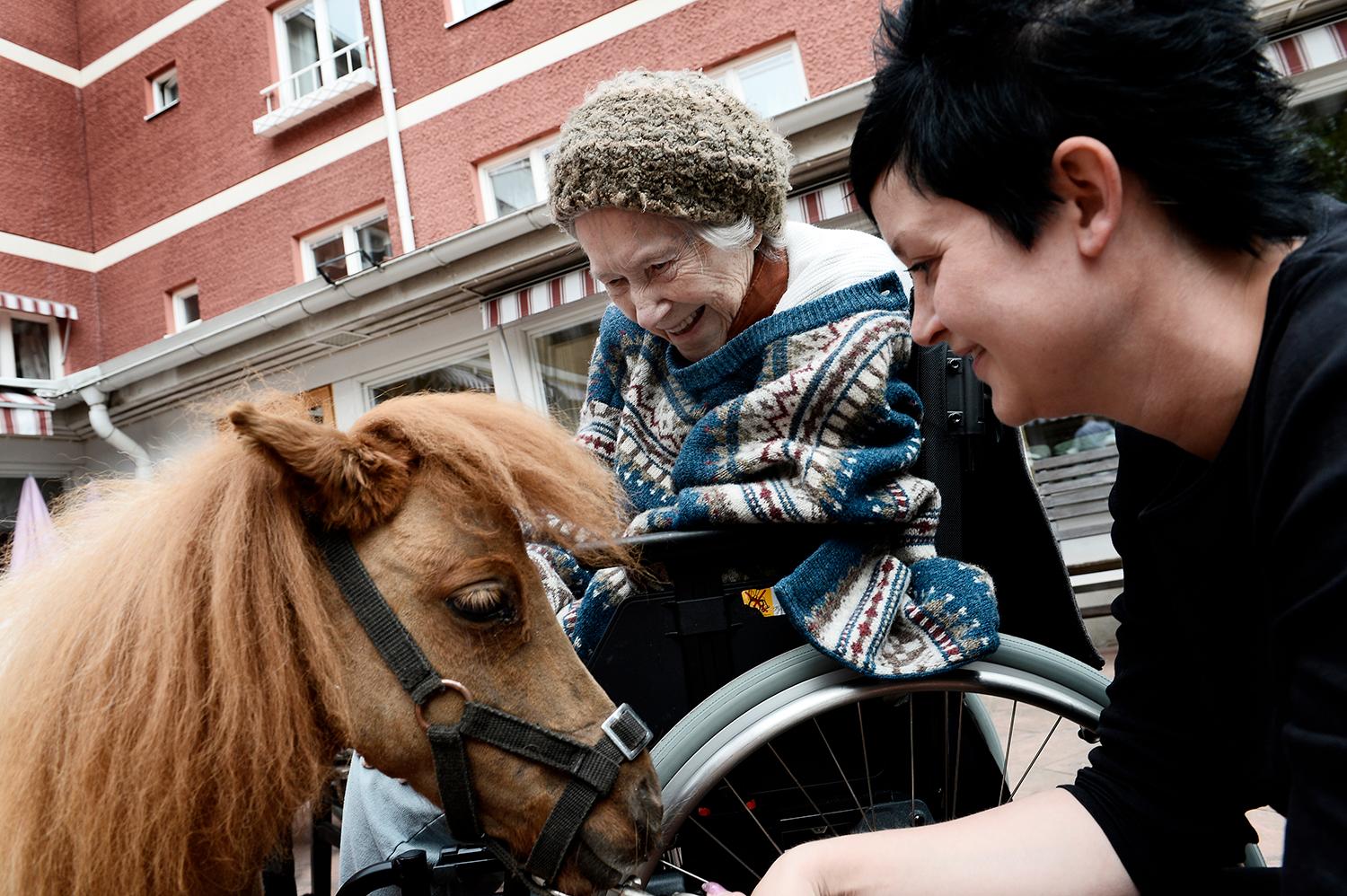 "Det skulle vara kul att ha en sån här" säger Helga Jansson, 93, till Therese Saarinen medan hon klappar hästen Bibbi.