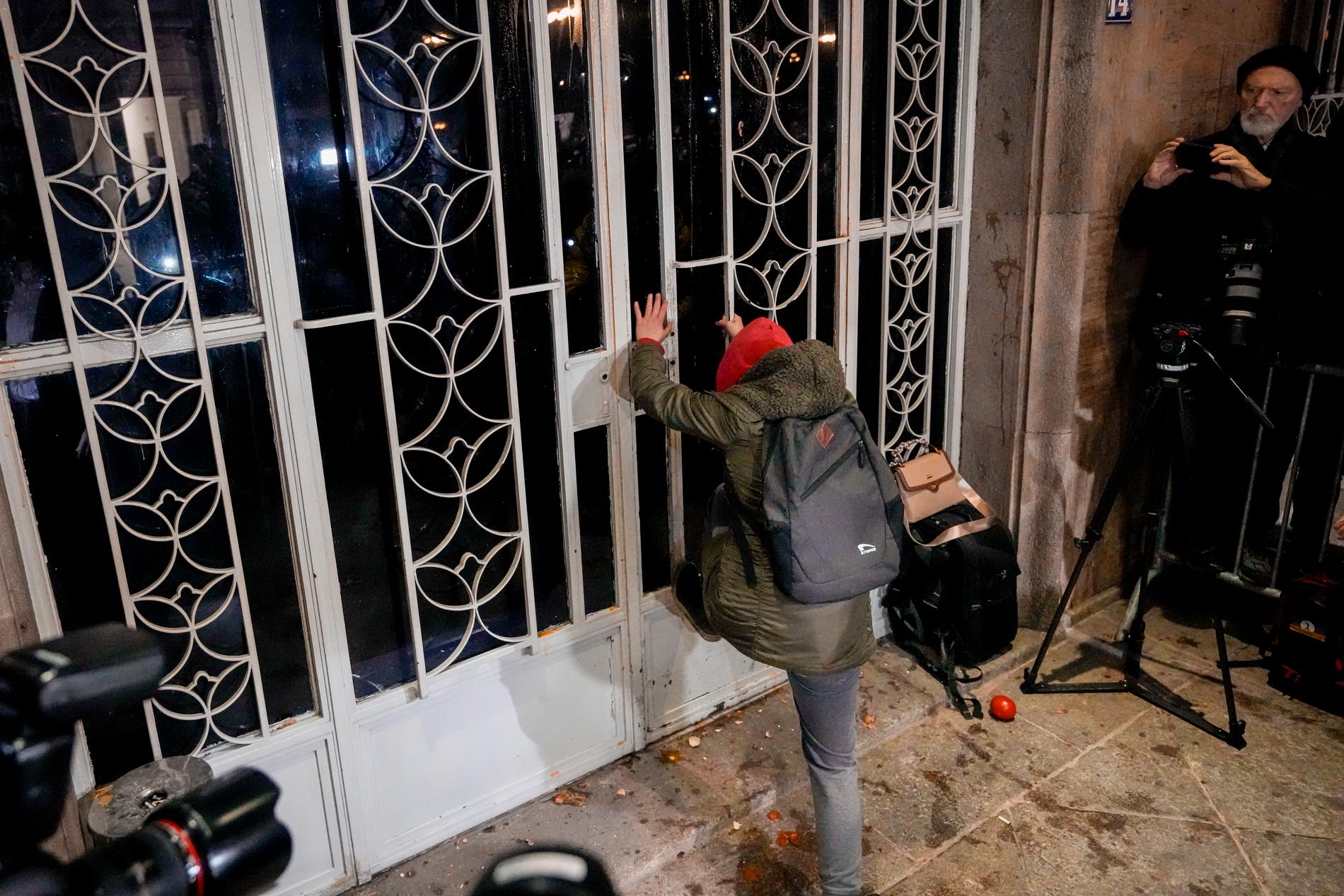 En demonstrant försöker spraka in dörren till den serbiska valmyndigheten i Belgrad.