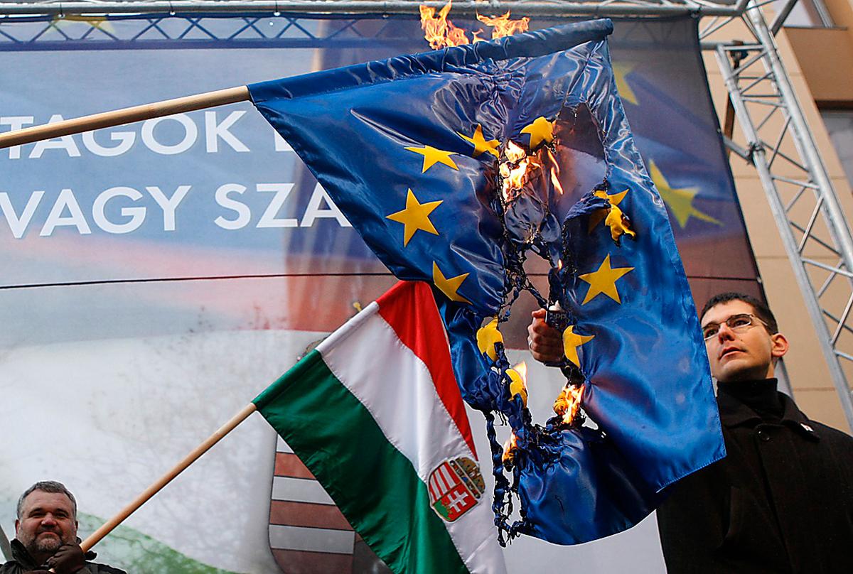 En medlem i ungerska högerextrema partiet Jobbik bränner en EU-flagga.