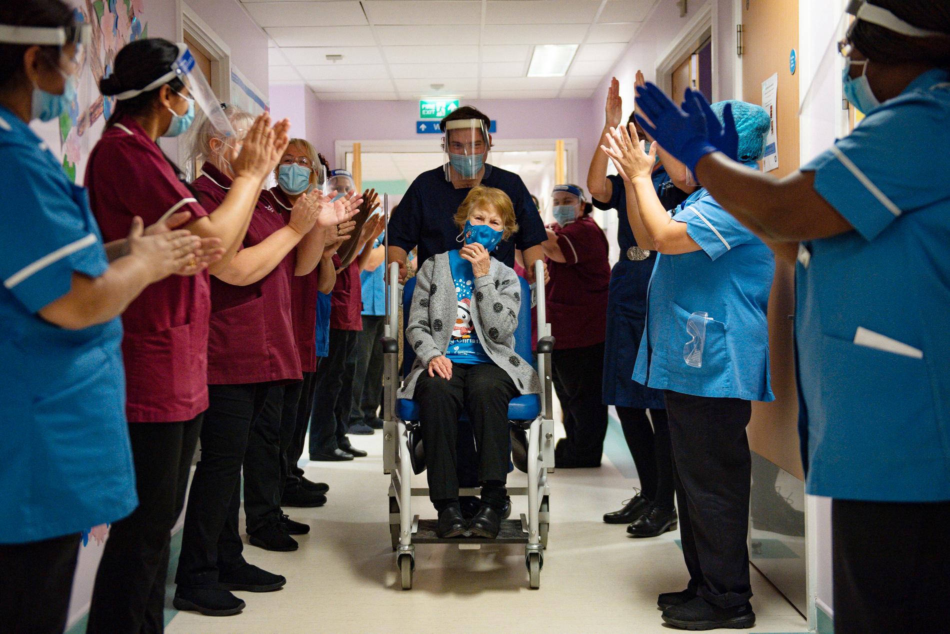 Margaret Keenan, 90, möts av  applåder från personalen på University Hospital,  England efter att ha fått landets första vaccin mot covid-19.