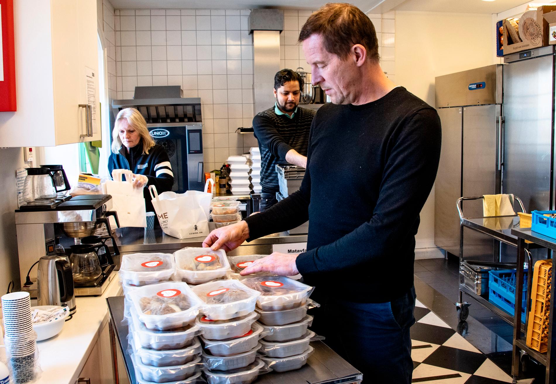 Stockholms Stadsmission St Paul i full färd med att packa ihop matlådor. Platschefen Erik Holmberg, samt Carina och Ammad i köket.