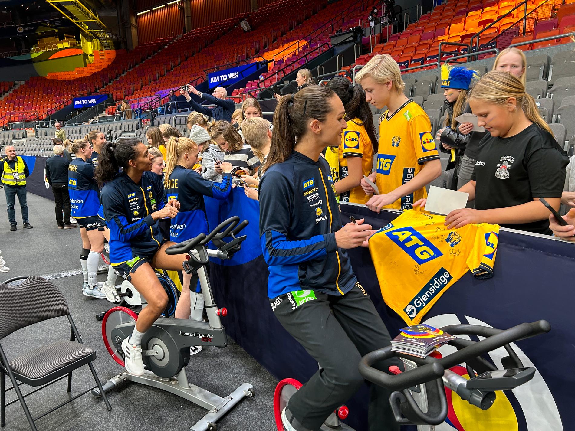 Svenska spelarna cyklar ner efter matchen och skriver autografer samtidigt. 