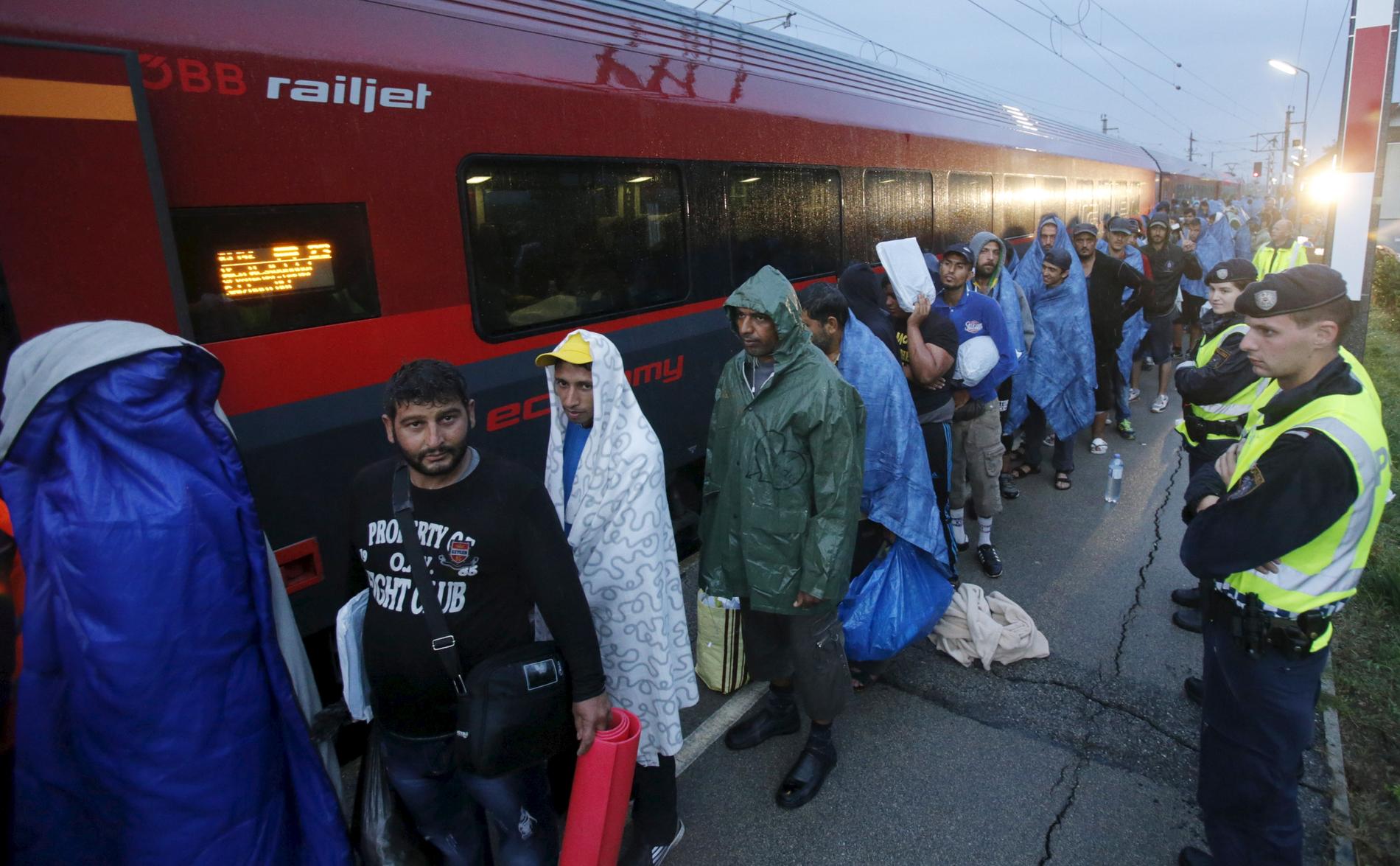 Migranter som kommit fram till Österrike köar till ett tåg mot Tyskland.